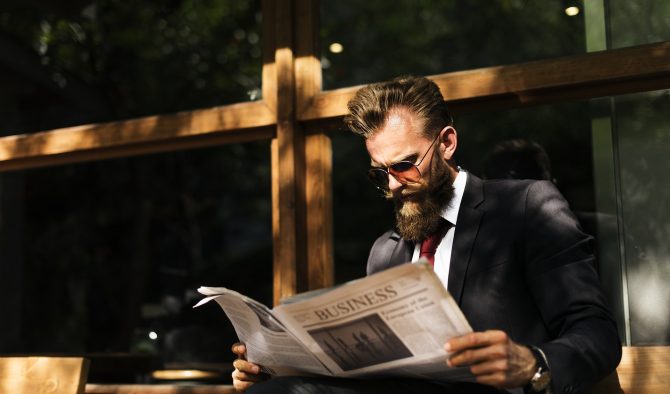 Bärtiger Mann liest Zeitung