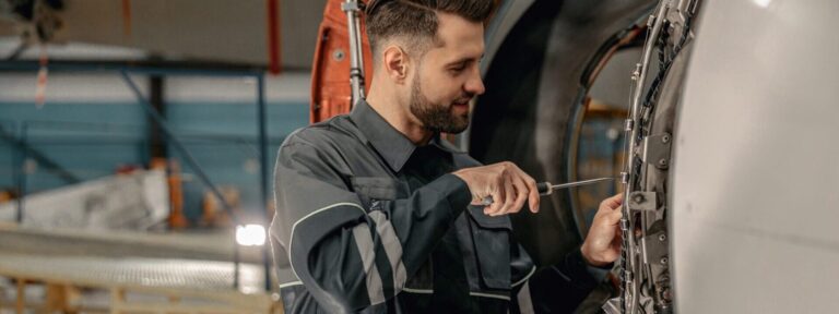 Smiling,Man,Airline,Maintenance,Technician,Using,Screwdriver,While,Repairing,Airplane
